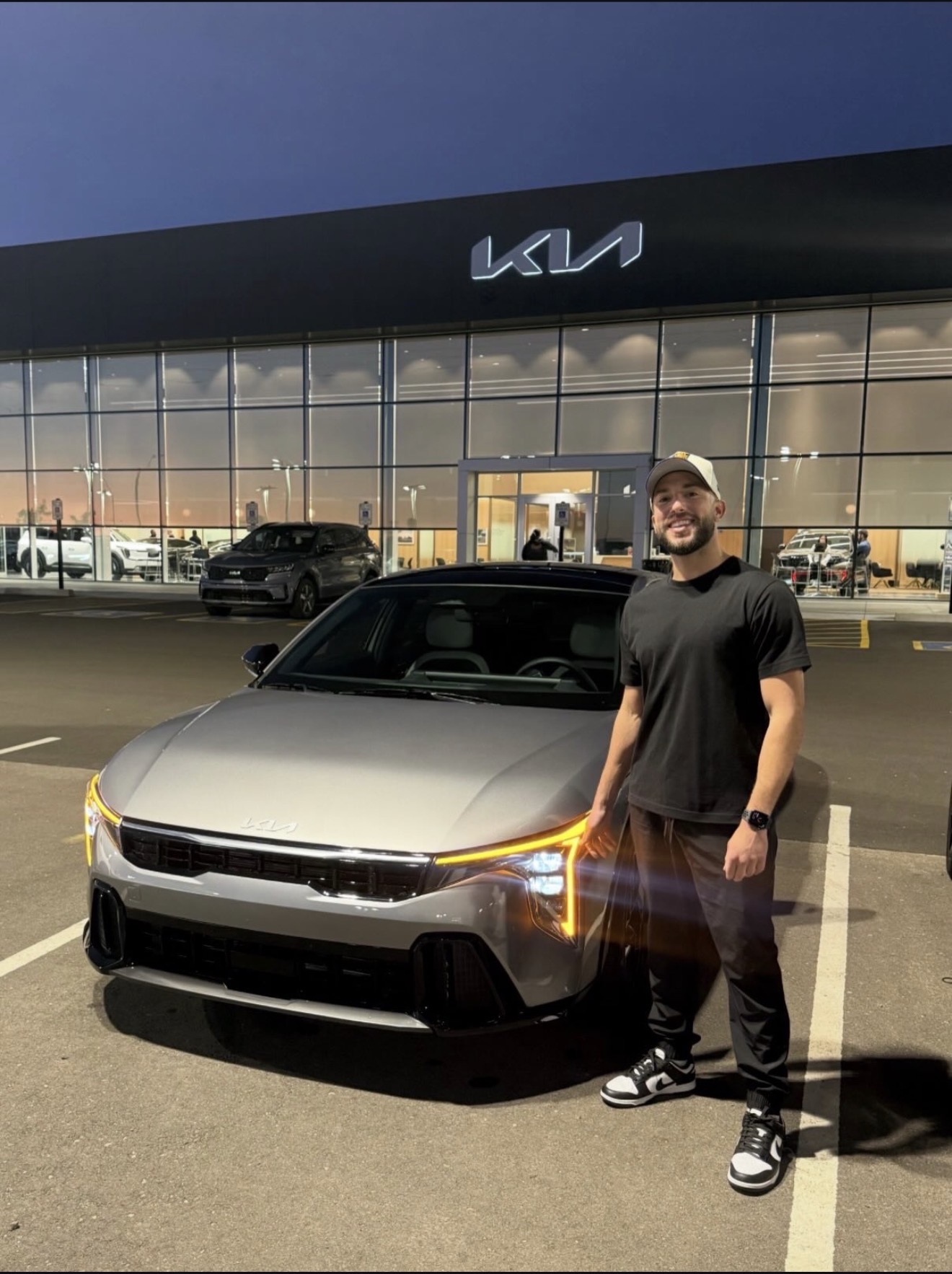 CJ's Auto Consulting client with their new Kia at the dealership